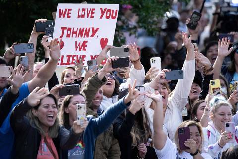 TOPSHOT - Fans cheer as US actor Johnny Depp arrives at the Fairfax County Circuit Courthouse in Fairfax, Virginia, on May 26, 2022. - Actor Johnny Depp is suing ex-wife Amber Heard for libel after she wrote an op-ed piece in The Washington Post in 2018 referring to herself as a public figure representing domestic abuse. (Photo by Brendan Smialowski / AFP) ORG XMIT: BSX_6507.NEF
