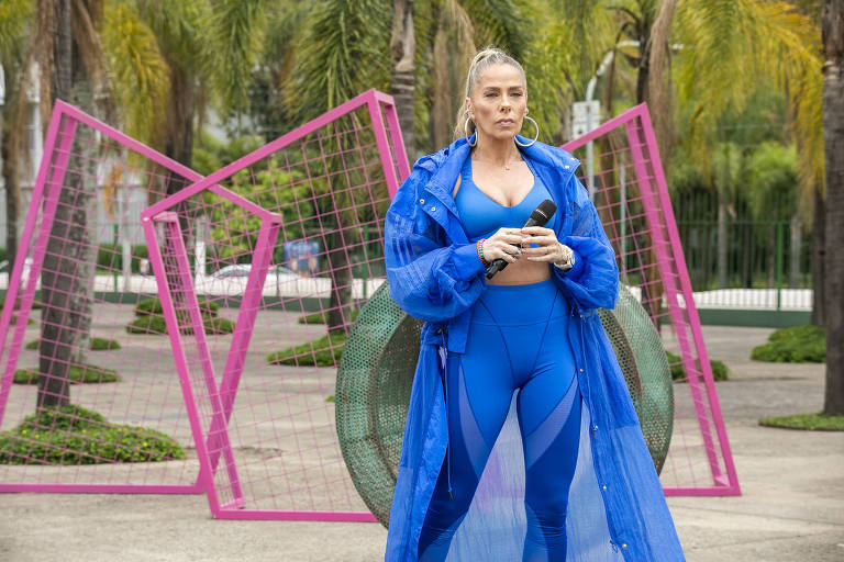 Adriane Galisteu, aparece toda vestida de azul, na frente de um dos obstáculos da prova de casal do "Power Couple Brasil"