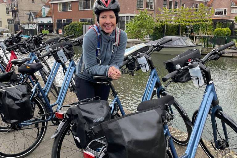 Mulher posa com bicicleta e uniforme de ciclista, com capacete