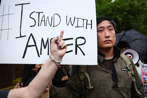 SENSITIVE MATERIAL. THIS IMAGE MAY OFFEND OR DISTURB    Dan Kim, 26, holds a sign in support of Amber Heard amidst throngs of Johnny Depp fans, outside the Fairfax County Circuit Courthouse on the final day of the defamation trial of Johnny Depp versus Amber Heard in Fairfax, Virginia, U.S., May 27, 2022. REUTERS/Evelyn Hockstein ORG XMIT: PPP-WAS301