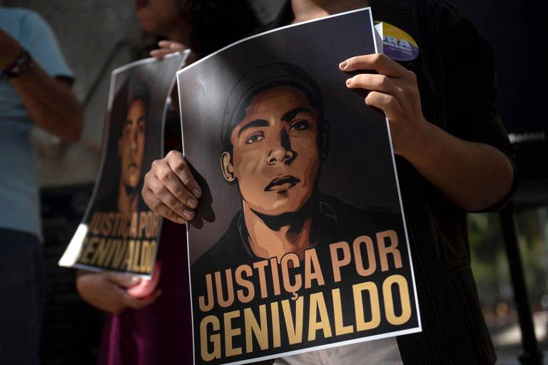 Manifestante segura cartaz onde se lê "justiça por Genivaldo", com uma ilustração do rosto da vítima