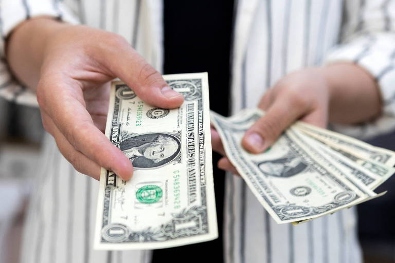 Mulher manipula notas de dólar