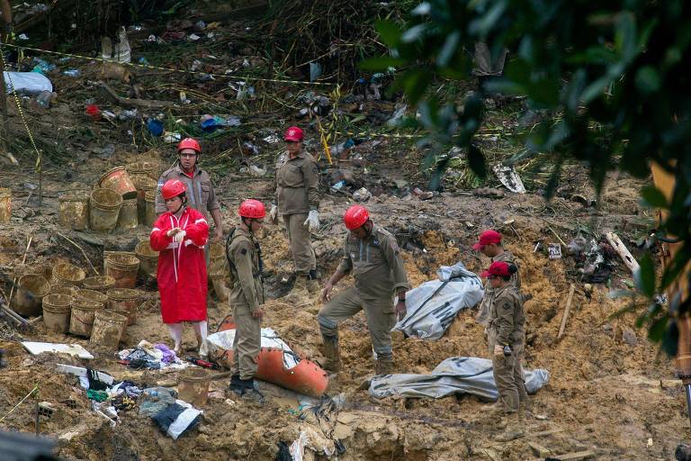 Bombeiros tiram da lama os corpos de três vítimas de deslizamentos na Vila dos Milagres, em Recife