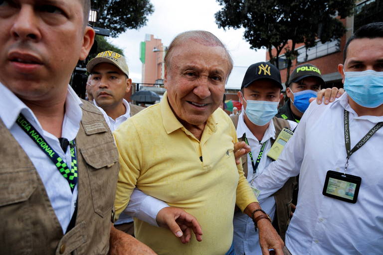 Com camisa amarela e ladeado por seguranças e apoiadores, Rodolfo Hernández, que disputará o segundo turno da eleição presidencial na Colômbia contra Gustavo Petro, caminha em rua de  Bucaramanga depois de votar