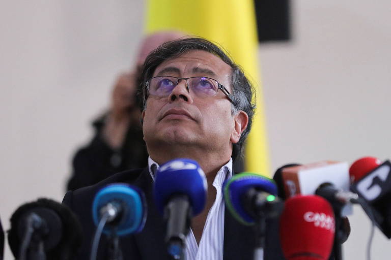 Gustavo Petro, que representará a esquerda no 2º turno da eleição presidencial colombiana, olha para cima em visita ao Congresso do país; ele usa óculos e há microfones diante dele