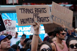 FILE PHOTO: People protest U.S. President Donald Trump's announcement that he plans to reinstate a ban on transgender individuals from serving in any capacity in the U.S. military, in Times Square, in New York City