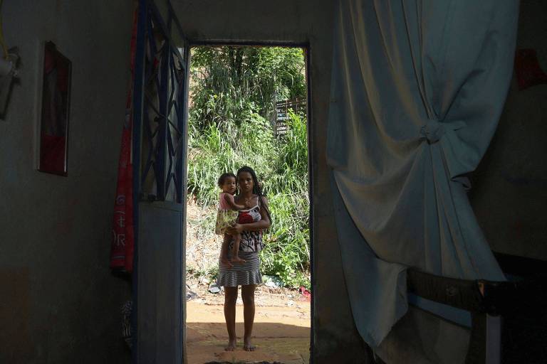 Rayza Dayane, de 25 anos, posa com sua filha, Clara Rhayllane, 1, na entrada de sua casa na Vila dos Milagres, um dos locais ainda com perigo de deslizamentos por causa das fortes chuvas