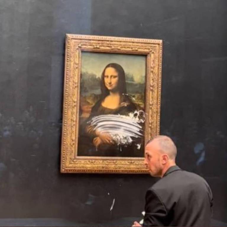 A pintura 'Mona Lisa' é atingida por uma torta, que atingiu apenas o vidro que a protege, no Museu do Louvre
