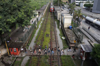 Passageiros fazem travessia pelos trilhos na estação Antonio João da CPTM