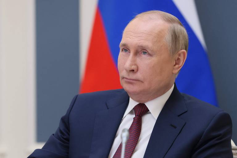Vladimir Putin, presidente da Rússia, em frente à bandeira do país.