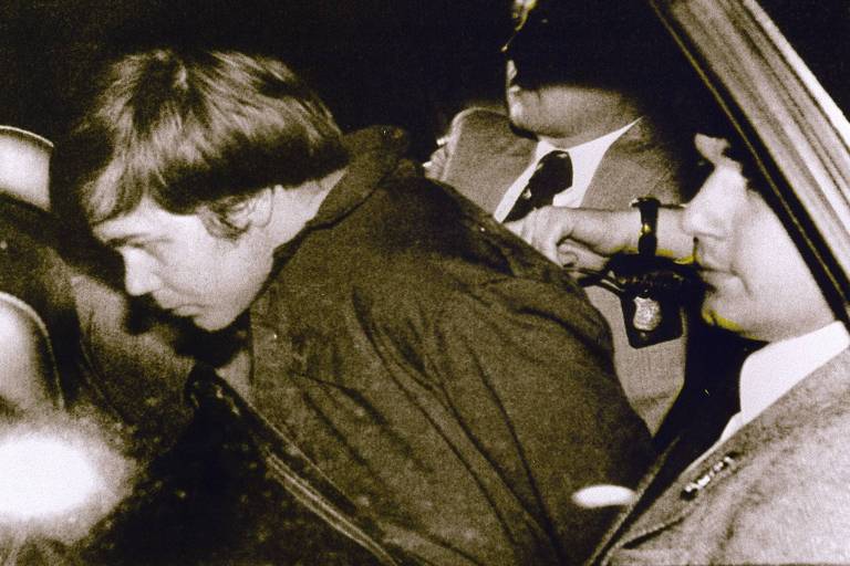 John Hinckley Jr. é escoltado pela polícia em Washington após ser preso por atirar contra o então presidente dos EUA, Ronald Reagan