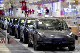FILE PHOTO: Tesla China-made Model 3 vehicles are seen during a delivery event at the carmaker's factory in Shanghai, China