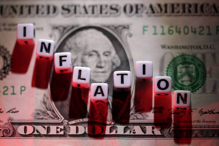 Letras de plástico formando a palavra 'inflation' (inflação) sobre nota de dólar americano; temor da inflação derruba mercados nesta segunda (13)