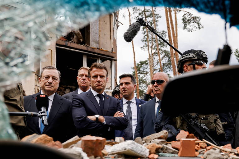 O presidente da França, Emmanuel Macron, ao centro, de braços cruzados, o premiê da Itália, Mario Draghi, à esq., e o líder da Romênia, Klaus Iohannis, durante visita a Irpin