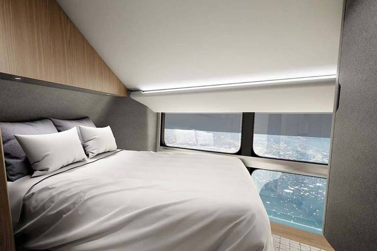 Uma cama de casal, em um quarto com vista para o mar e porções de neve.