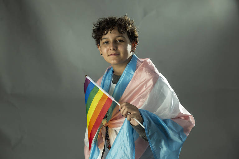 Lucca Santos Simões, 11, que foi à Parada com sua mãe, com bandeira gay e trans