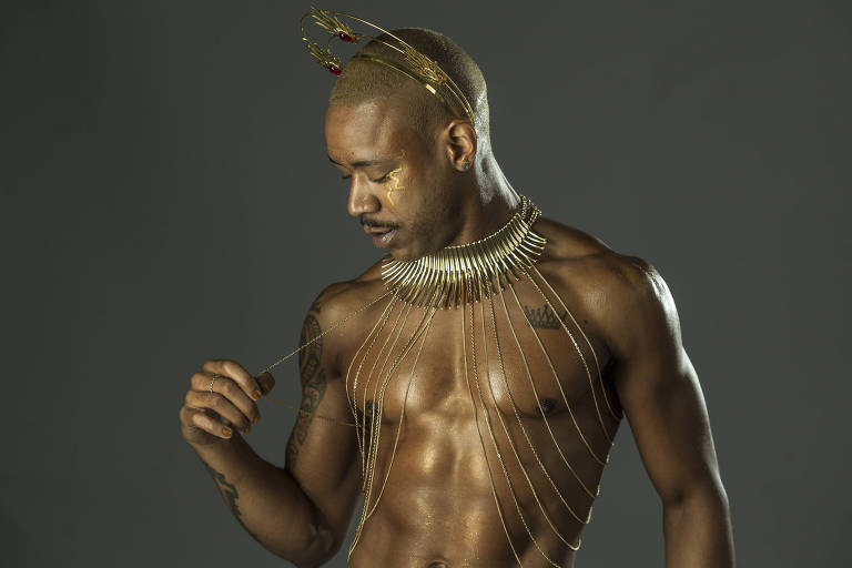 Lucas Scudellari, 27, modelo e ator pornô, negro, de torso nu e adereços dourados