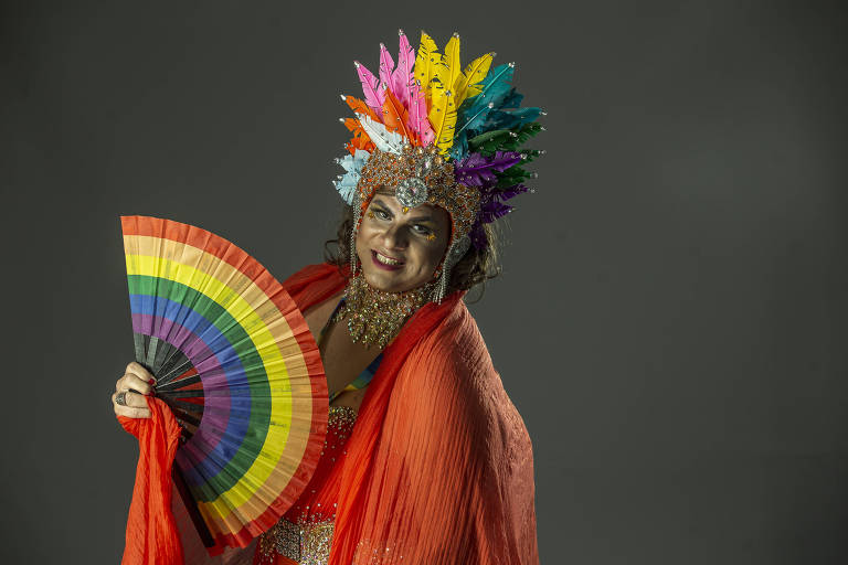Leônidas Ferraz, 36, veio de Betim (MG) e se define como queer. Com leque e tiara das cores do arco-íris