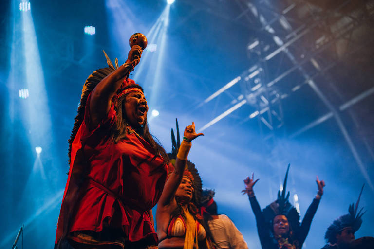 Maria Florguerreira (esq.) e outros indígenas pataxós sobem ao palco durante show da banda Francisco, el Hombre no festival Forró da Lua Cheia, em Altinópolis, perto de Ribeirão Preto (interior de SP)