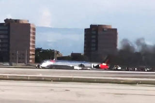 Plane catches fire, on belly at Miami airport