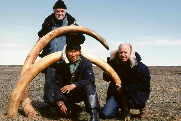 Yves Coppens (em pé) com Bernard Buigues (à dir.) e Guenary Zharkov posam com as presas de um mamute na Sibéria em 1999