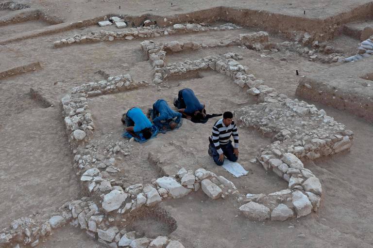 Trabalhadores muçulmanos oram no local onde descobriram a mesquita de 1.200 anos, em Rahat, Israel