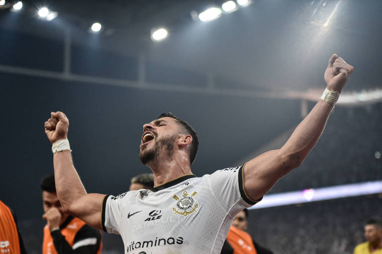Jogador do Corinthians ergue braços em comemoração 