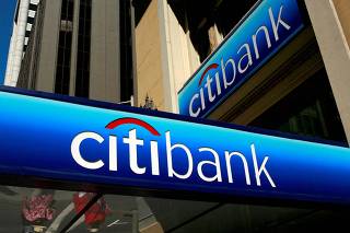 FILE PHOTO: People walk beneath a Citibank branch logo in the financial district of San Francisco, California