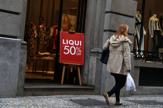 A woman walks past in front of a clothing store in Rio de Janeiro
