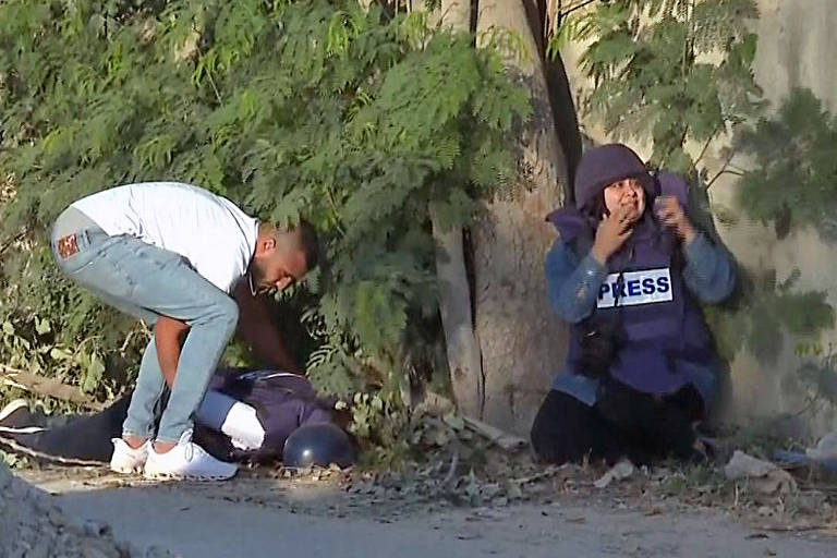Homem não identificado tenta levantar corpo da jornalista Shireen Abu Akleh, alvejada na Cisjordânia durante operação militar de Israel