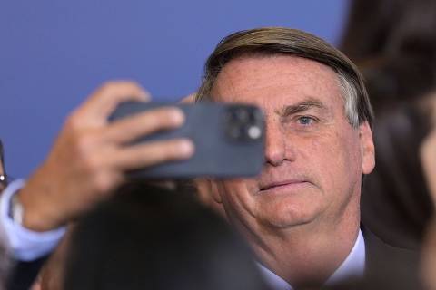 Brazilian President Jair Bolsonaro takes a selfie picture during the signing of an agreement with Google to facilitate access to free tools to strengthen the educational network across the country, at Planalto Palace in Brasilia on June 20, 2022. - Amid the crisis caused by rising fuel prices, Bolsonaro threatened to encourage the opening of commission in Congress to investigate the profits of Petrobras, a mixed-capital oil company under government control. (Photo by EVARISTO SA / AFP) ORG XMIT: ESA564