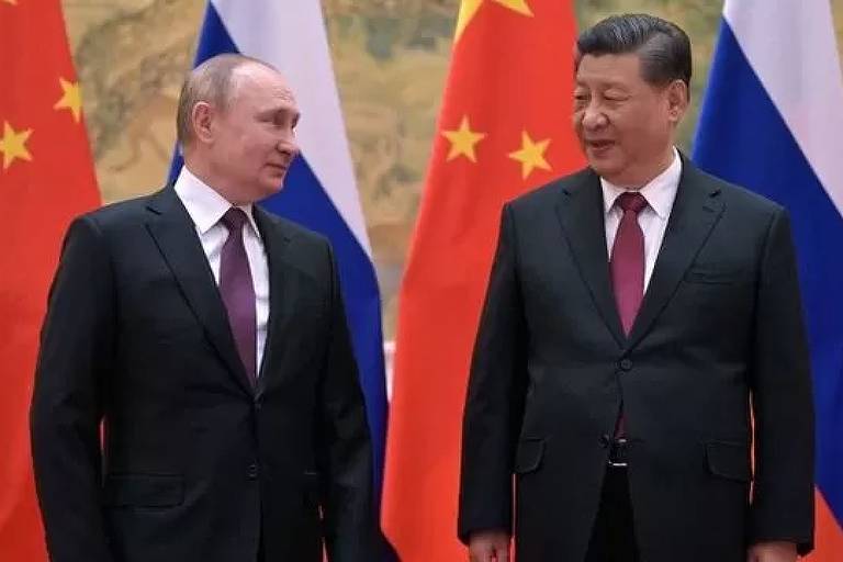 Putin e Xi em frente a bandeiras da Rússia e China
