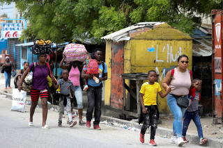 FILE PHOTO: Residents flee their homes after gun-battles between rival gangs in Port au Prince
