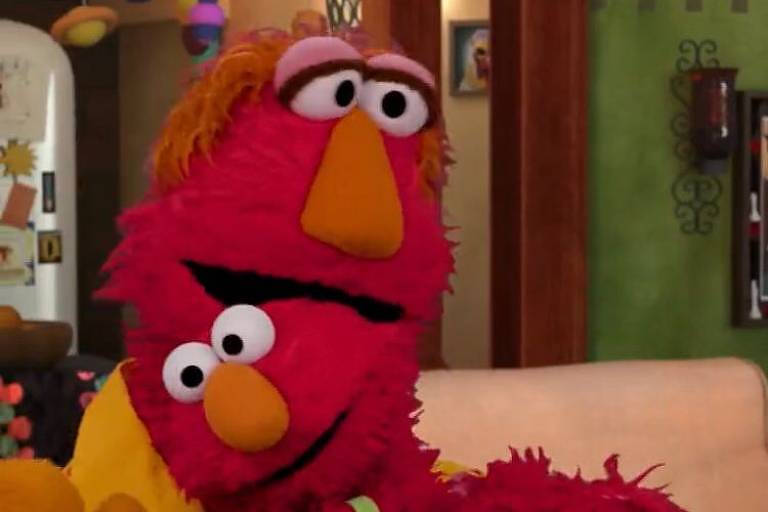 O personagem Elmo (abaixo) abraça seu pai, Louie, durante vídeo para incentivar a vacinação contra o coronavírus