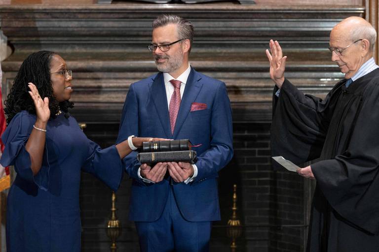 A juíza Ketanji Brown Jackson faz juramento ao lado do marido, Patrick Jackson (com a Bíblia), ao tomar posse na Suprema Corte dos EUA