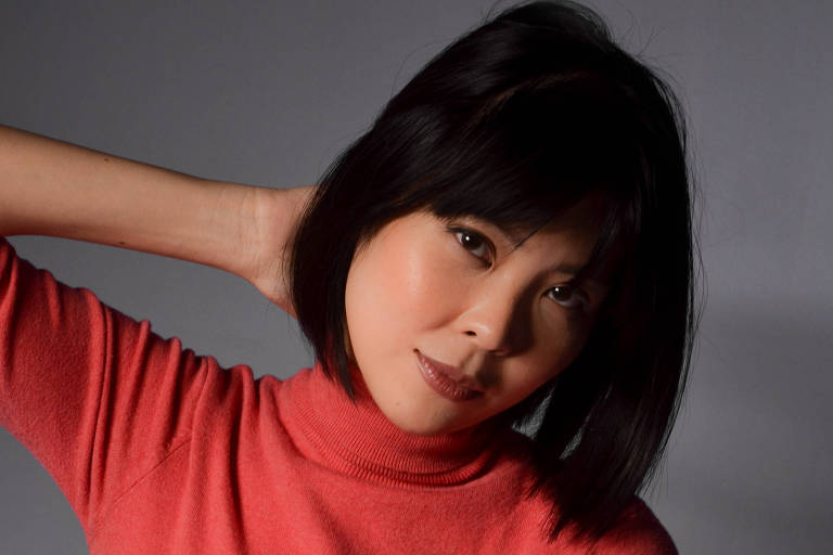 A atriz chinesa Chan Suan com blusa salmão de gola alta