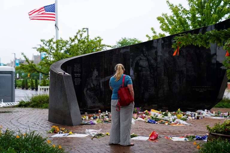 Mulher visita memorial montado em homenagem às vítimas de atentado em Highland Park, na região de Chicago, no feriado de 4 de Julho
