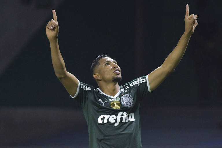 Vestindo a camisa verde do Palmeiras, que tem o patrocínio da Crefisa na altura do peito, Rony festeja, como os dedos indicadores apontados para o alto, gol contra o Cerro Porteño pela Libertadores de 2022