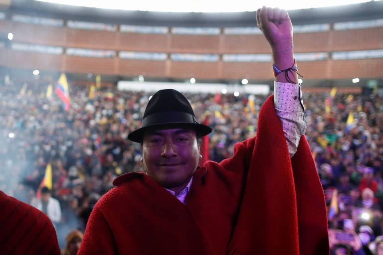O líder indígena Leonidas Iza, de chapéu preto e manto vermelho, festeja em Quito a assinatura de acordo com o governo do Equador