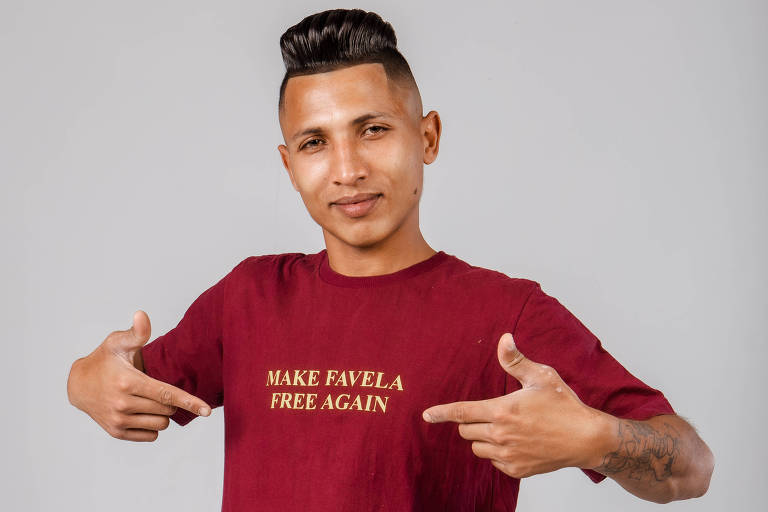 Cantor negro de blusa vermelha mostra camiseta escrita em inglês faça a favela ser livre de novo