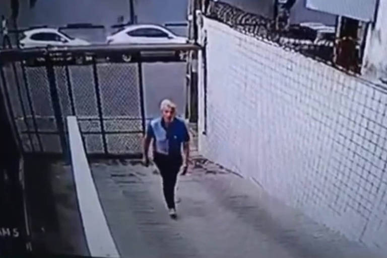 Câmera de segurança mostra o momento que o homem entra no prédio aproveitando que o portão da garagem estava aberto 