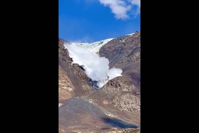 O vídeo mostra uma avalanche de neve entre montanhas