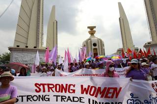 Women display banners during a rally for International Women's Day at the Democracy Monument in Bangkok