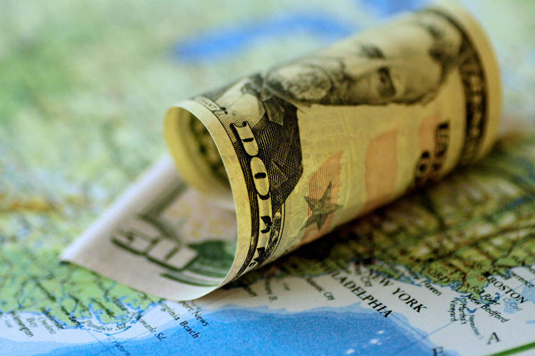 Uma nota de dólar posicionada sobre mapa