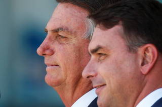 FILE PHOTO: Brazil's President Jair Bolsonaro looks on next to his son Senator Flavio Bolsonaro, during a welcoming ceremony to receive Brazilians and foreigners evacuated from Ukraine during a repatriation mission, at Brasilia Air Base, in Brasilia, Brazi