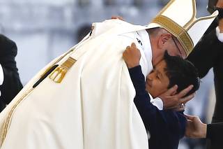 Pope Francis embraces Lucas Maeda de Oliveira as he leads the Holy Mass at the Shrine of Our Lady of Fatima in Portugal