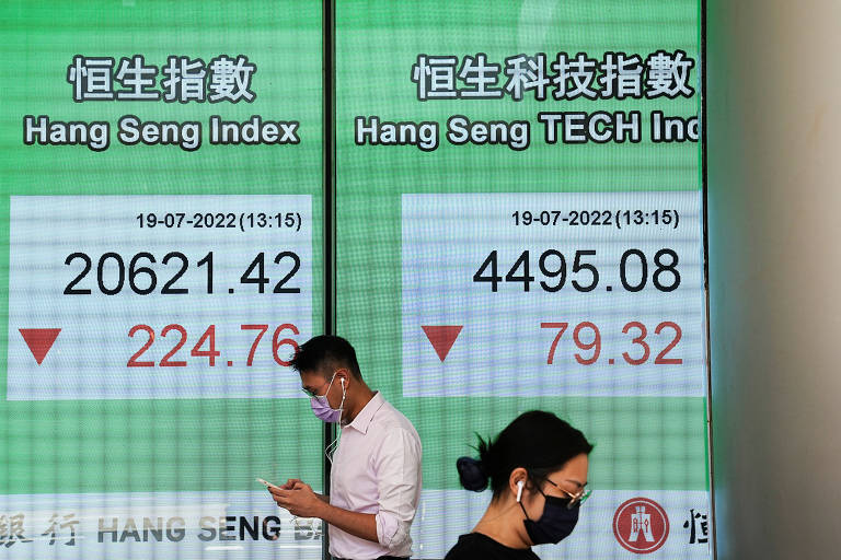 Pedestres diante de painel com índice da Bolsa de Hong Kong, na China