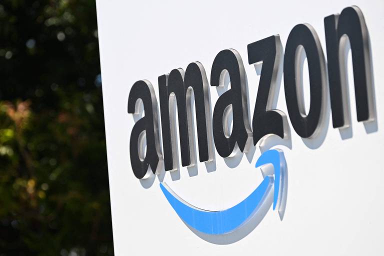 Imagem mostra logo da Amazon em uma placa. A palavra "amazon" está escrita em preto e embaixo há uma seta azul e curvilínea.