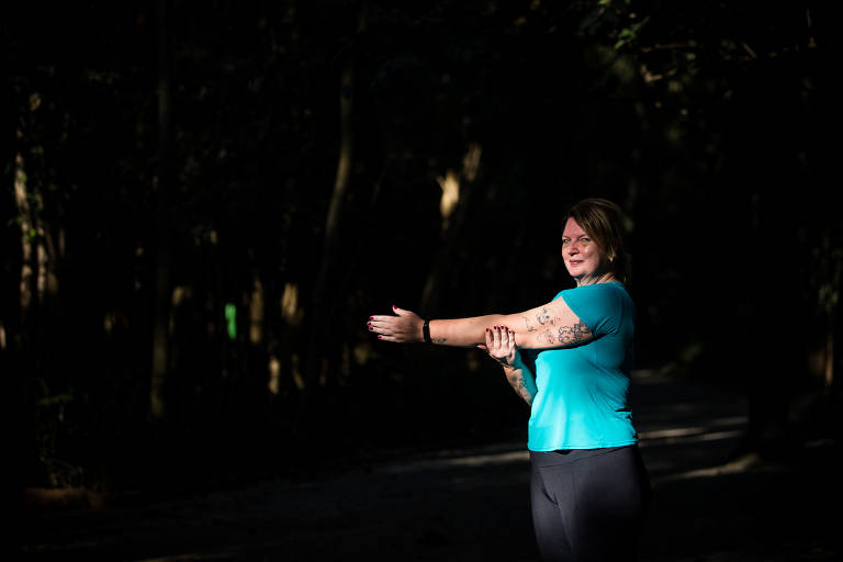 A empresária Andréa Bulbarelli, 52, faz alongamento para iniciar o treino de corrida no parque do Museu do Ipiranga