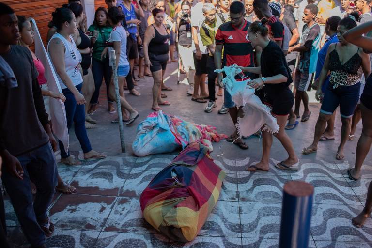 Moradores retiram corpo de homem baleado pela polícia durante operação policial no Complexo do Alemão, na zona norte do Rio de Janeiro; foram utilizados lençóis e toalhas parra carregar os mortos.